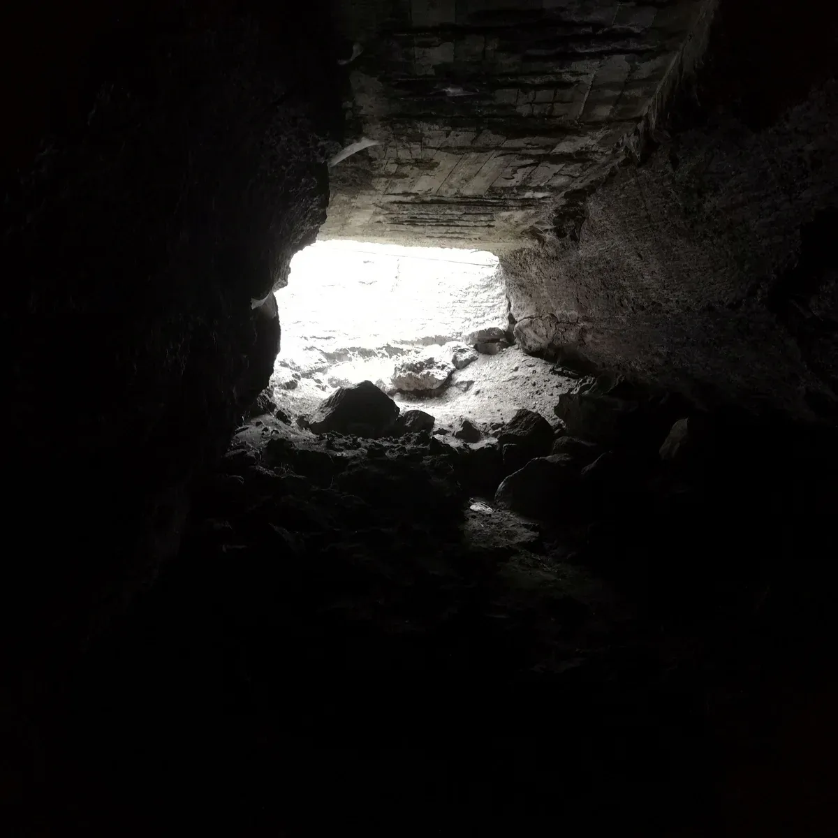 Looking out of a lava tube toward its entrance, the kind of cave visited on Mount Etna tours from Taormina, Sicily