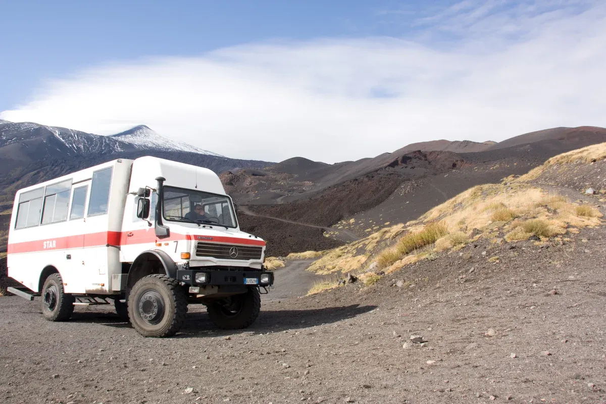 A Unimog 4x4 on the cinder track below the summit, the vehicle on the upper-crater Mount Etna tours from Taormina, Sicily